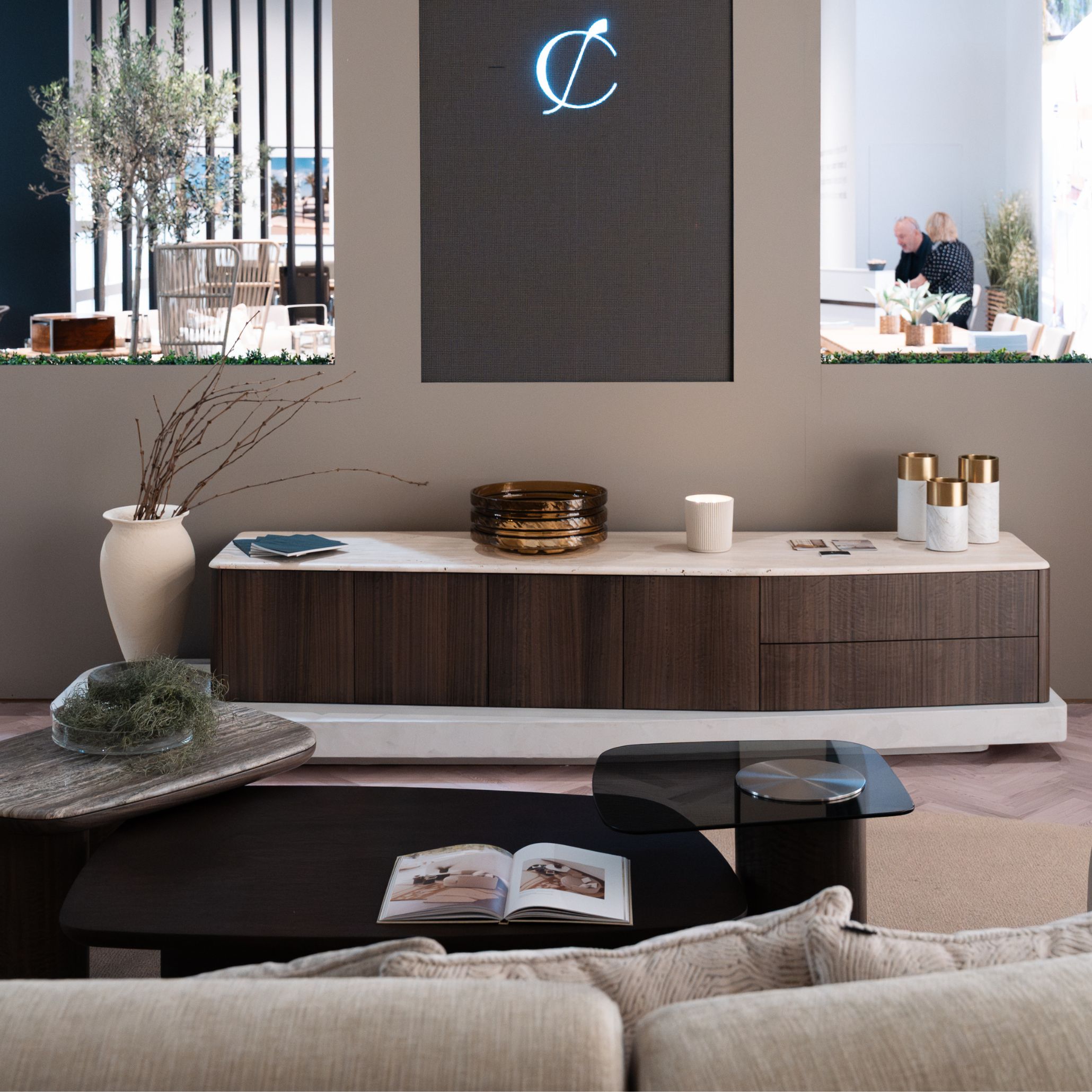 The living area features the Stone TV Cabinet paired with the Dolomites Coffee Table, creating a calm and grounded composition defined by natural textures and warm lighting. Soft upholstery and layered materials bring depth to the space, while decorative accents introduce subtle movement. This setting reflects a refined approach to living room furniture, enhanced by the sculptural presence of contemporary furniture and a layout shaped to offer gentle interior design inspiration.