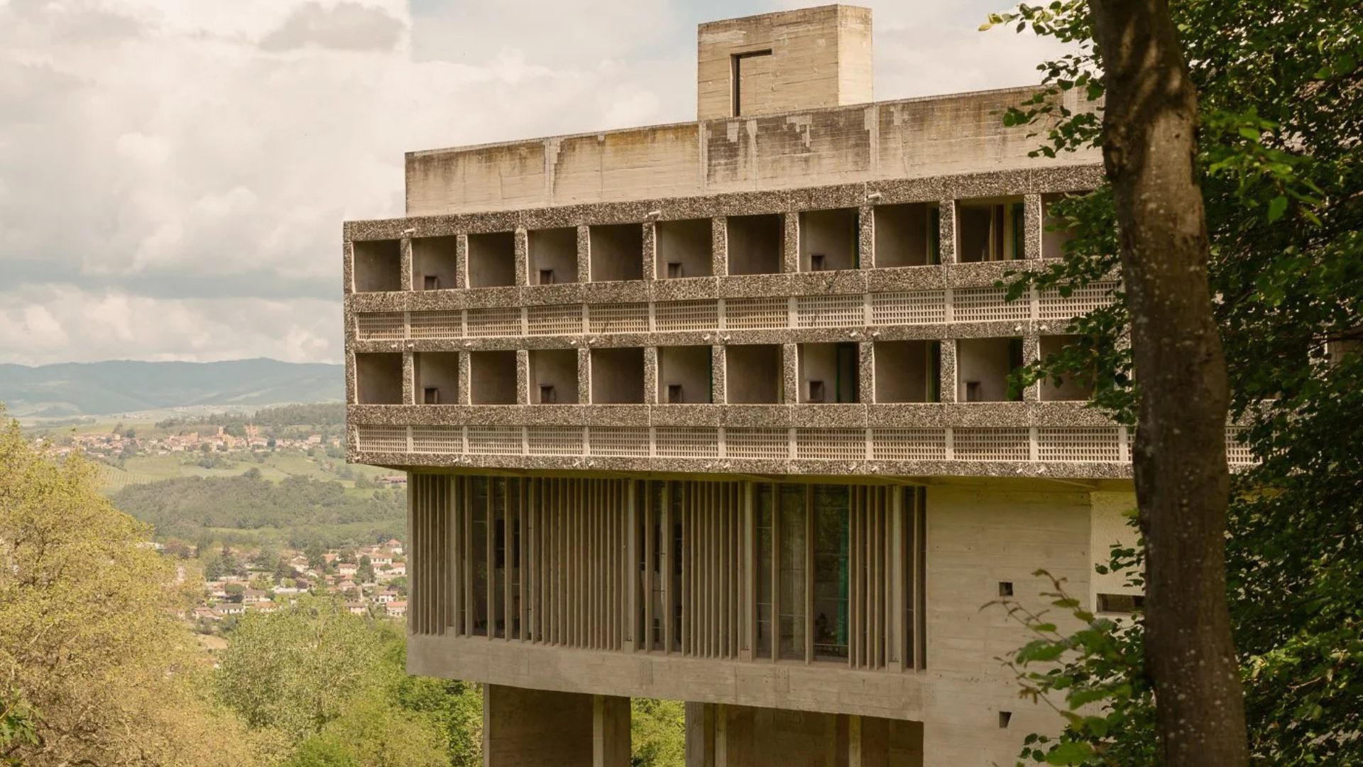 The concrete façade of Sainte Marie de La Tourette shows Le Corbusier’s disciplined modernism, with its strict grid of openings and elevated structure reflecting the clarity often sought in modern furniture, the restraint of luxury home furniture, and the functional purity that shapes interior design inspiration.