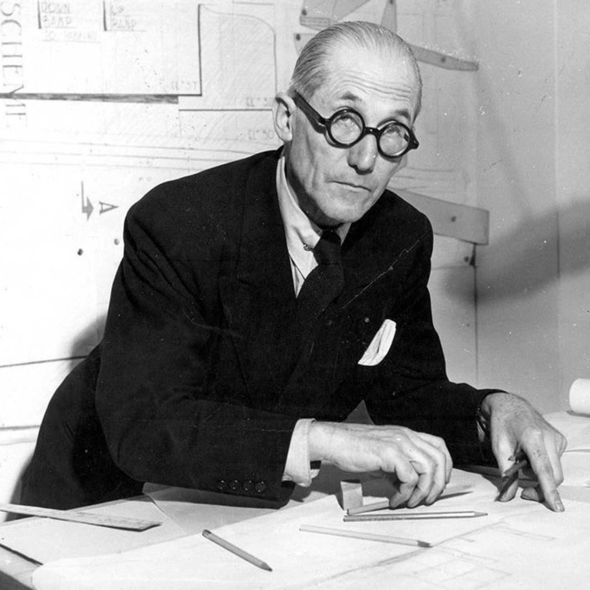 Le Corbusier sits at his drafting table, sketching architectural studies that reflect the precision and clarity he brought to modern design, principles that would later influence luxury home furniture, the evolution of modern furniture, and the broader world of interior design inspiration.