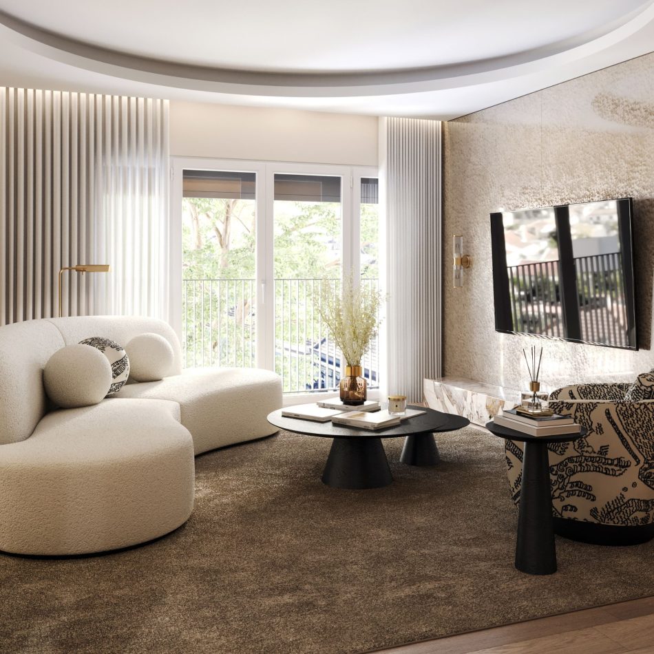The living room features the Cotton cream sofa with round cushions, paired with a patterned Her armchair and two wood tables styled with books, a brown glass vase, and dried florals. A wall‑mounted TV and warm brass sconce sit against a textured beige wall, while large glass doors open to a balcony overlooking green trees, filling the space with natural light. This calm, cohesive setting reflects refined living room furniture, elevated by the clarity of contemporary furniture, and arranged to evoke warm living room inspiration.