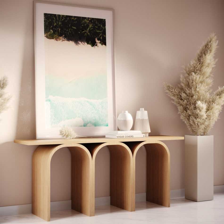 The Antónia Console stands beneath a large coastal artwork, its sculptural arches grounding the space with quiet architectural presence. Soft neutral tones, ceramic vases and dried grasses create a serene, contemporary ambiance that feels warm and curated. The scene reflects luxurious homedecor, crafted luxury furniture and calm, nature‑inspired interior design.