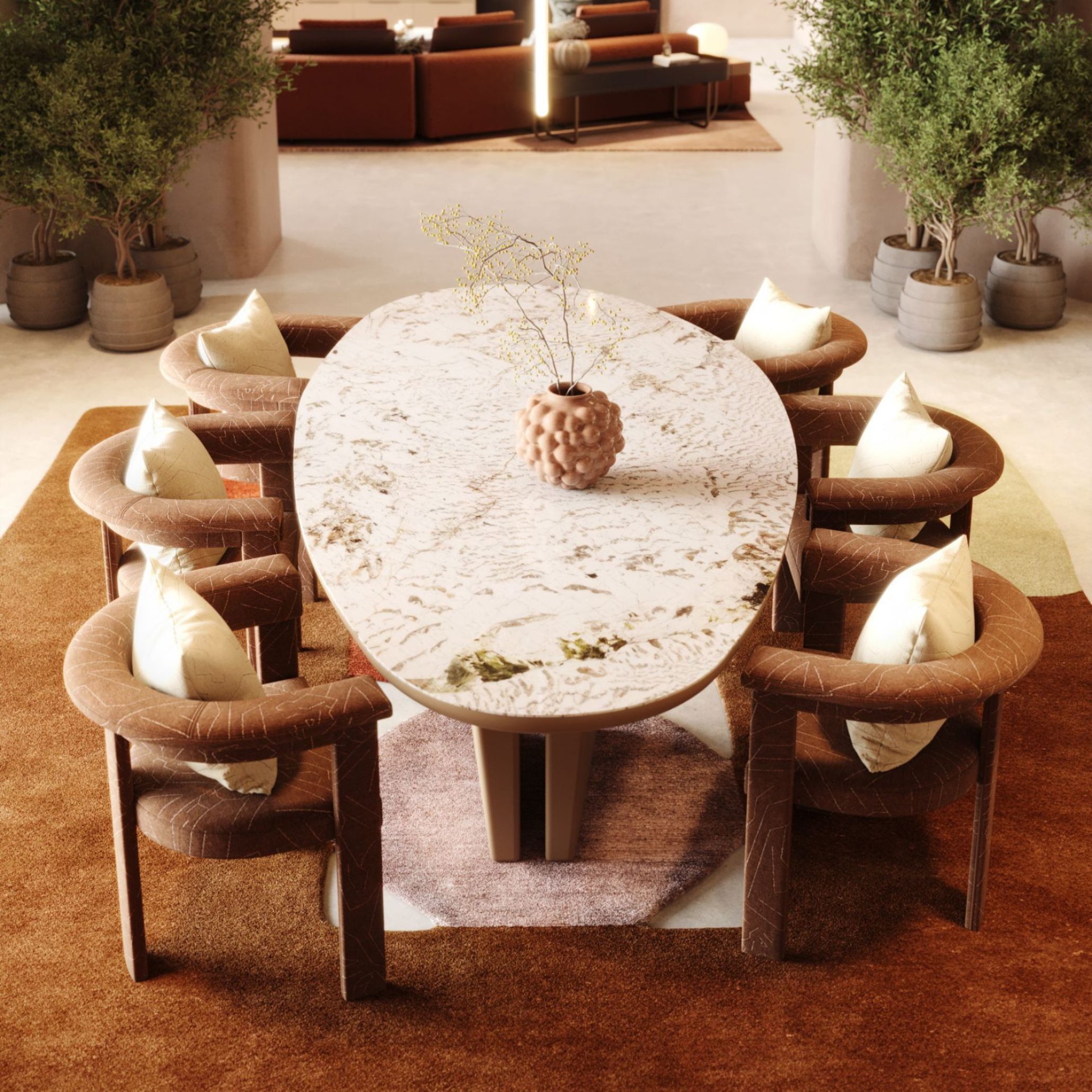The Stone Dining Table, shaped with a light, textured stone surface and gentle mineral veining, anchors a warm dining room surrounded by curved upholstered chairs and earthy tones. Its organic silhouette recalls the slow, natural shaping of river stones, creating a calm gathering point where life unfolds. The scene reflects elegant stone craftsmanship, the grounded presence of organic furniture, and the warmth of nature inspired interiors.