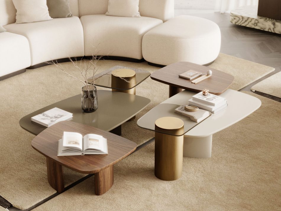 A close arrangement of the Dolomites Coffee Table set sits before the curved Stone Sofa, combining mixed materials and rounded forms in a calm, layered composition. Books, sculptural objects and natural textures soften the scene, illuminated by filtered daylight. The moment expresses crafted living room furniture, understated luxury furniture and the gentle balance of minimalist design.