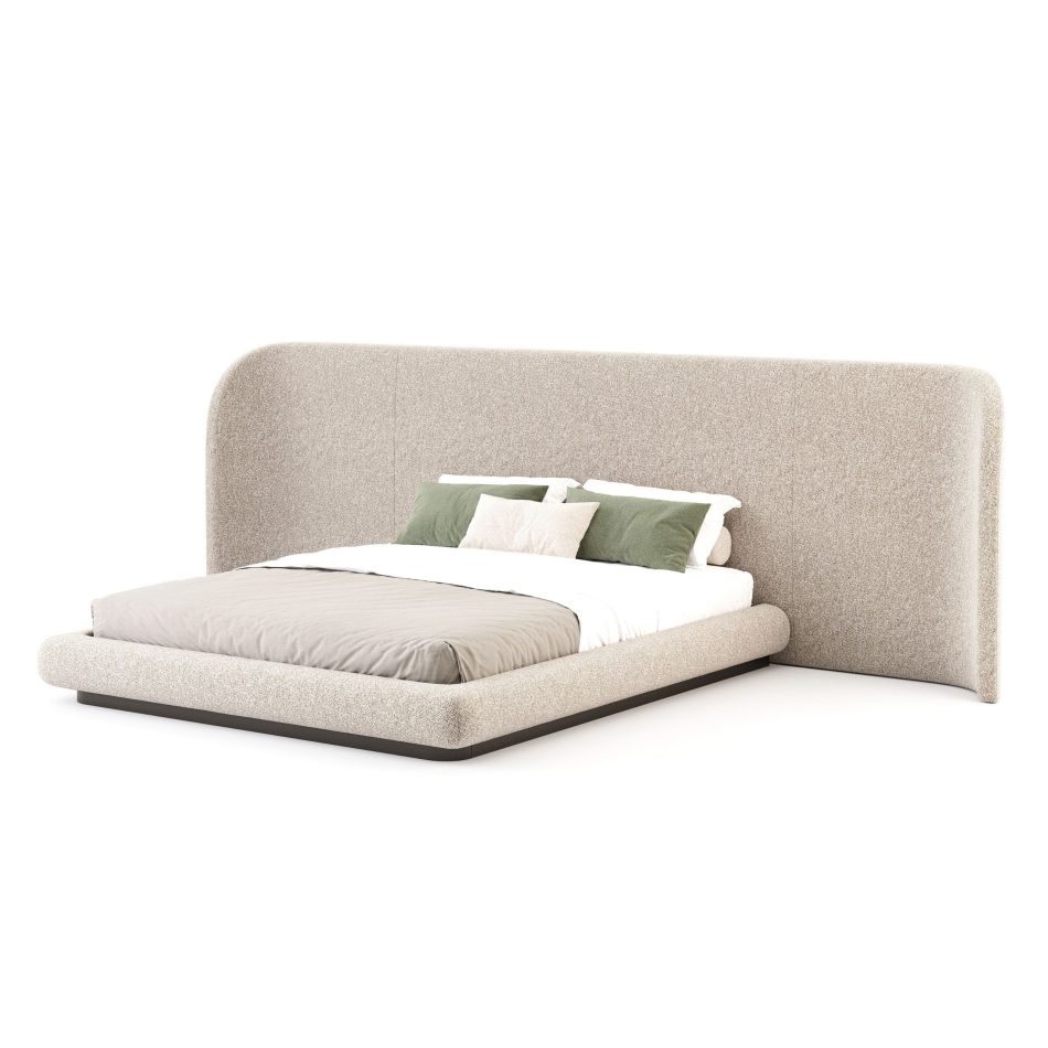 A side view reveals the Stone Bed’s continuous curved headboard and low upholstered frame, styled with minimalist bedding. The organic form introduces sophisticated bedroom furniture, soft design details, and a grounded elegance that enhances modern bedroom furniture.