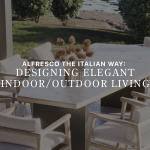 Banner image of the alfresco living, featuring the Escarpa Dining Table with a marble top and dark metal base, surrounded by the Toro Chair in natural solid wood with cream upholstery. Set on an open terrace with a manicured garden backdrop, this luxury dining table set captures the essence of bespoke dining room design brought outdoors, reflecting the Italian approach to seamless indoor-outdoor flow.