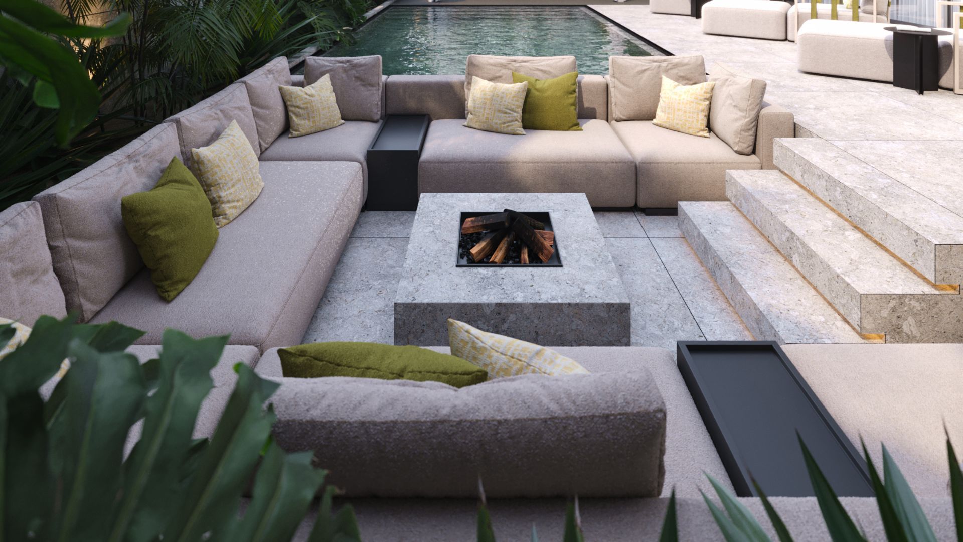 A sunken alfresco lounge centred around a stone fire pit, where the generous modular His Sofa wraps the space in a U-shape, its textured upholstery layered with olive green and yellow cushions. The bespoke living room configuration sits at pool level, framed by tropical greenery and stone steps that descend from the terrace above. This living room architecture demonstrates how a fire pit and a well-chosen sofa transform an outdoor space into a place of genuine warmth and living room inspiration after dark.