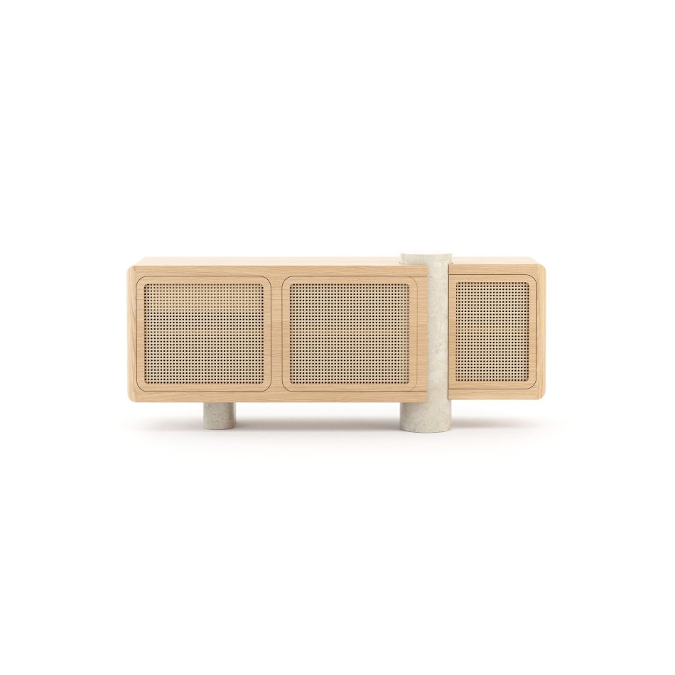 The Antónia Sideboard, displaying its complete length and symmetry. Three woven cane door panels span the front, framed by clean oak wood edges, while two cylindrical travertine marble legs rise from the floor to support the case, with the marble column continuing upward between the cabinet sections. A striking example of casegoods furniture that pairs solid wood with natural stone detailing.