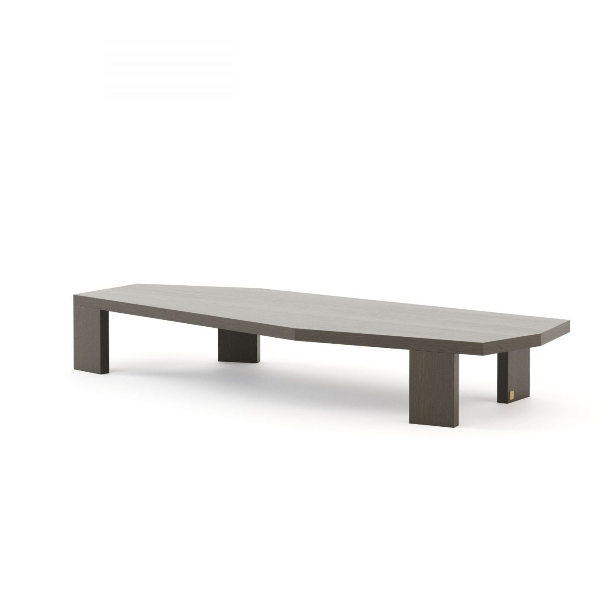 The Escarpa Coffee Table in a dark grey-toned solid wood veneer, featuring a long gently curved top resting on four square block legs with a small brass detail. Its harsh and strict lines and low horizontal profile bring a grounded architectural quality to the living room furniture, reflecting the Comporta principle of choosing pieces built with care, honesty and enduring character.
