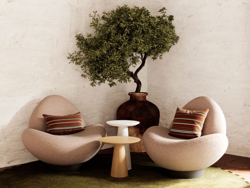 Two Stone Armchairs in soft textured upholstery create an intimate retreat within the open space, paired with the Olivier Side Table in marble and wood. Terracotta flooring, a green rug, and a large potted plant introduce natural warmth, blending living room furniture, gentle design details, and sun‑washed interior design inspiration.