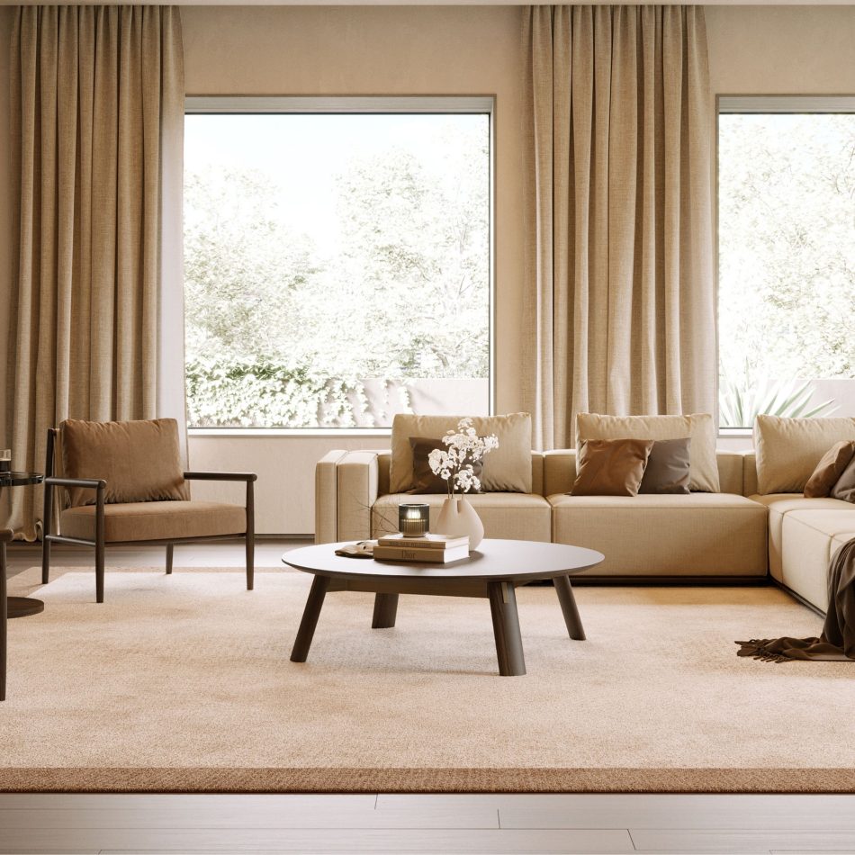 The Landform Coffee Table sits low on a beige rug in a sunlit living room, its dark oak oval top styled with books, a candle, and a vase of white flowers, set against beige sofas, a curved-arm accent chair, and tall linen drapes. Its rounded silhouette and angled legs bring a luxury coffee table presence to the contemporary furniture scheme.