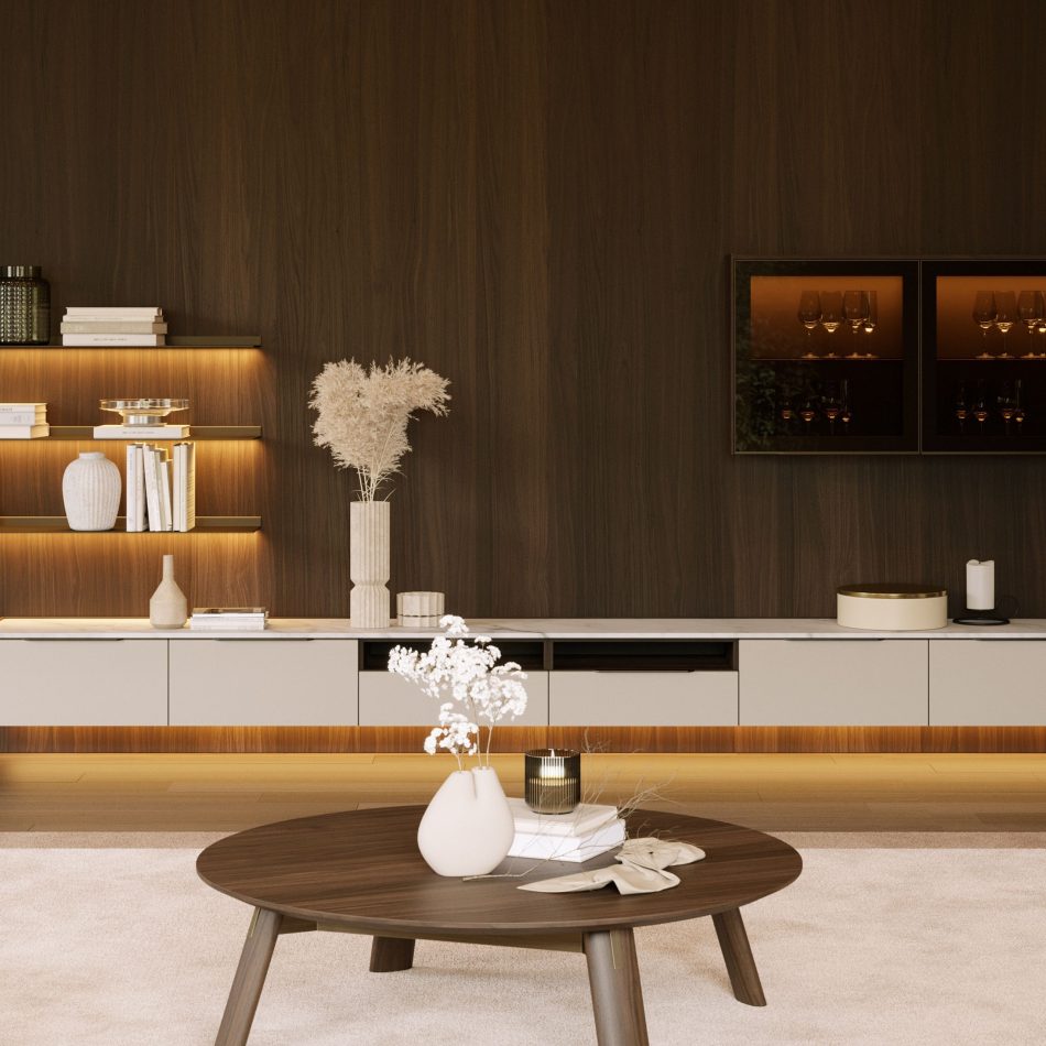 In a warm, walnut-paneled lounge with backlit shelving and ambient gold lighting, the Landform Coffee Table's round dark oak top anchors the room, holding a textured vase, dried pampas grass, and a glass candle holder. The piece's calm geometry and grounded stance embody modern furniture wood design within this rich, contemporary furniture interior.