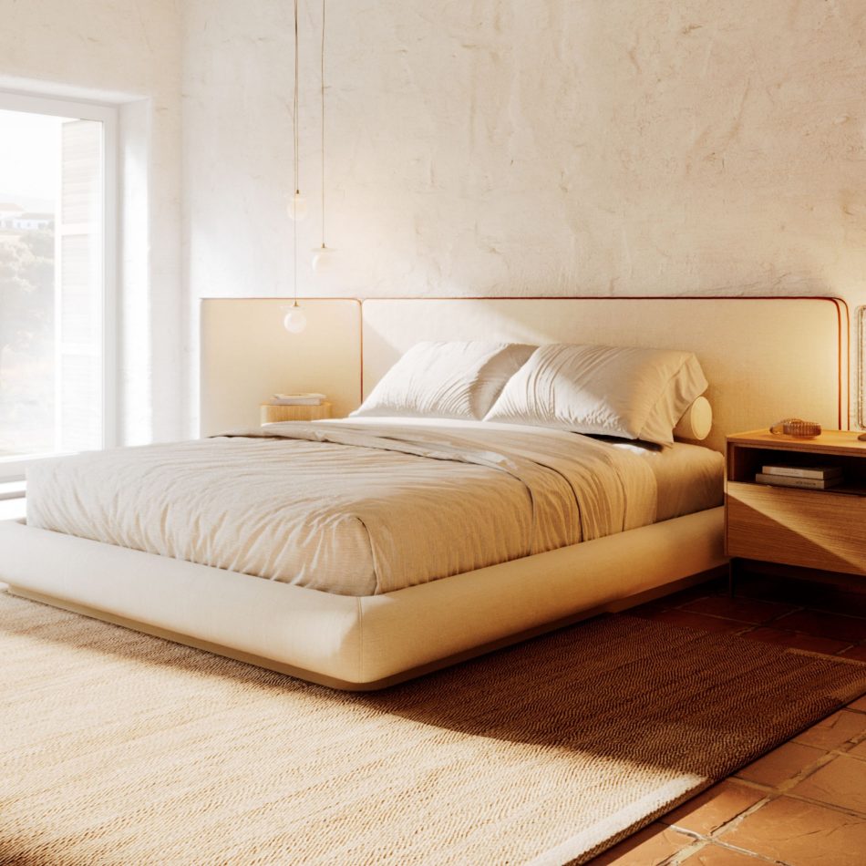 Warm Comporta-style bedroom with textured plaster walls and terracotta tiles, featuring the Natur Bed in cream furniture upholstery fabric with its characteristic wide panel headboard trimmed in terracotta piping, sitting low on its platform frame over a woven natural rug. The Landform Night Table I in solid wood is visible to the right, completing a bespoke bedroom of calm and considered luxury bedroom furniture design.