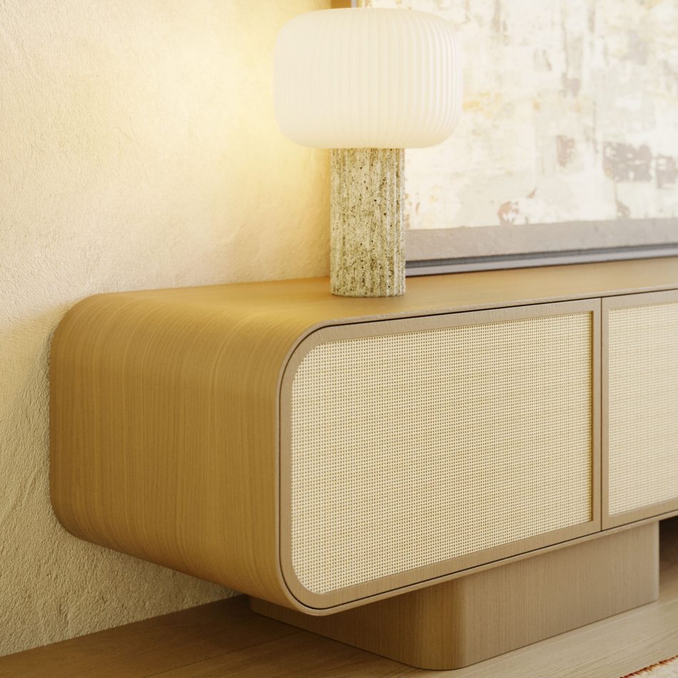 A close detail of the Natur TV Cabinet shows the curved corner of its finest wood body meeting a woven rattan door front, set beneath a textured ceramic table lamp. Sunlight from a nearby window catches the wood grain, highlighting the design details that define this tv cabinet. The composition reflects living room furniture built on craftsmanship and quiet material honesty.