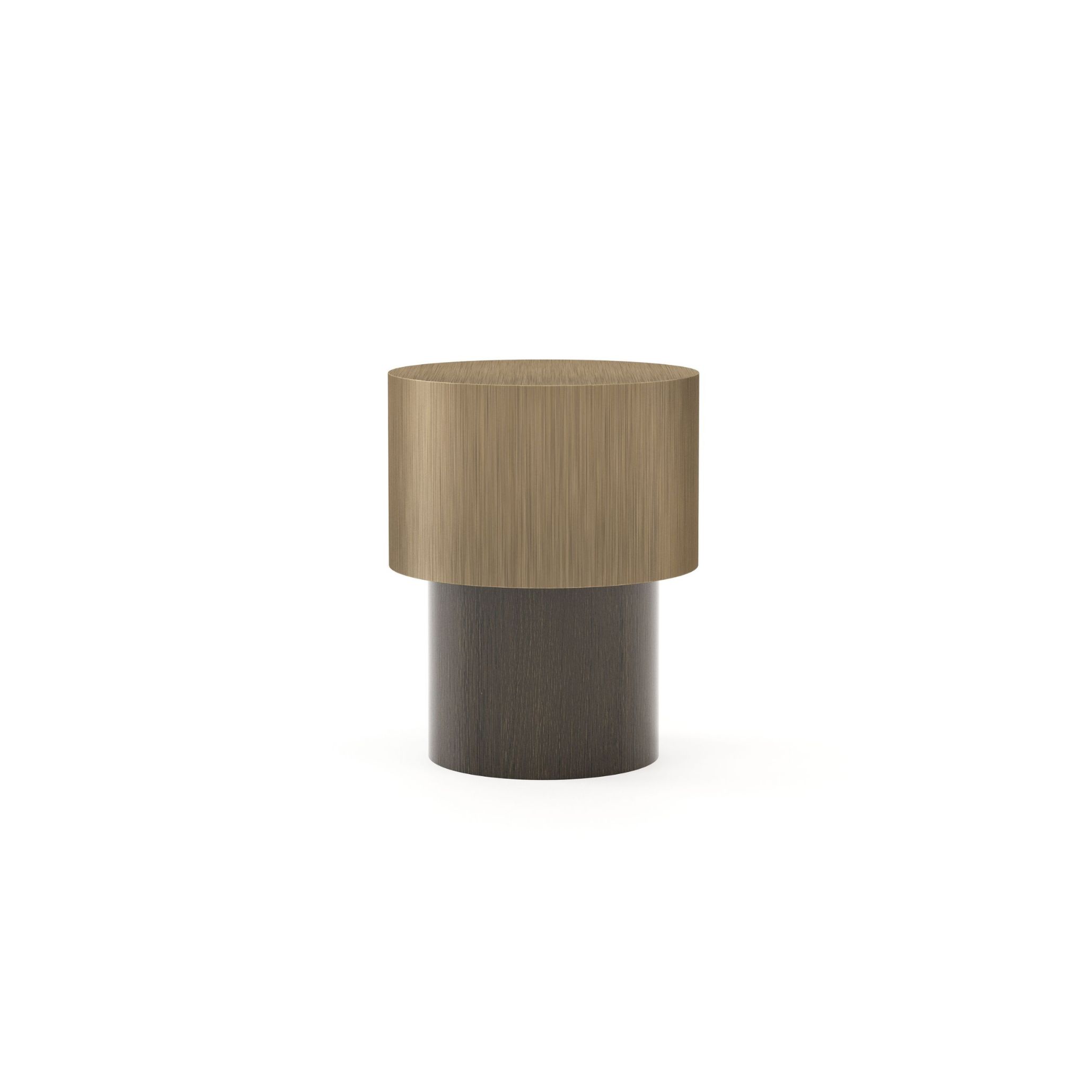 The Toro Side Table I sits on a white background, its two-toned cylindrical form pairing a wide top in light brass with a narrower base in dark finest wood. Compact and material-forward, the piece carries a quiet self-assurance true to Van Duysen's design values.