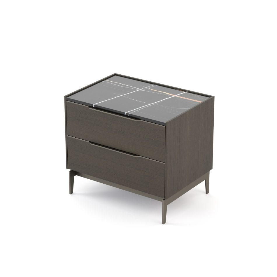 The Landform Night Table II stands on a white background, its dark wood body topped with a marble top in Sahara Noir, crossed by white and copper veining. Two flush drawers sit beneath, elevated on slender tapered metal legs. The design details of this piece of luxury bedroom furniture reflect a quiet duality and contrast between dark wood and dark stone.