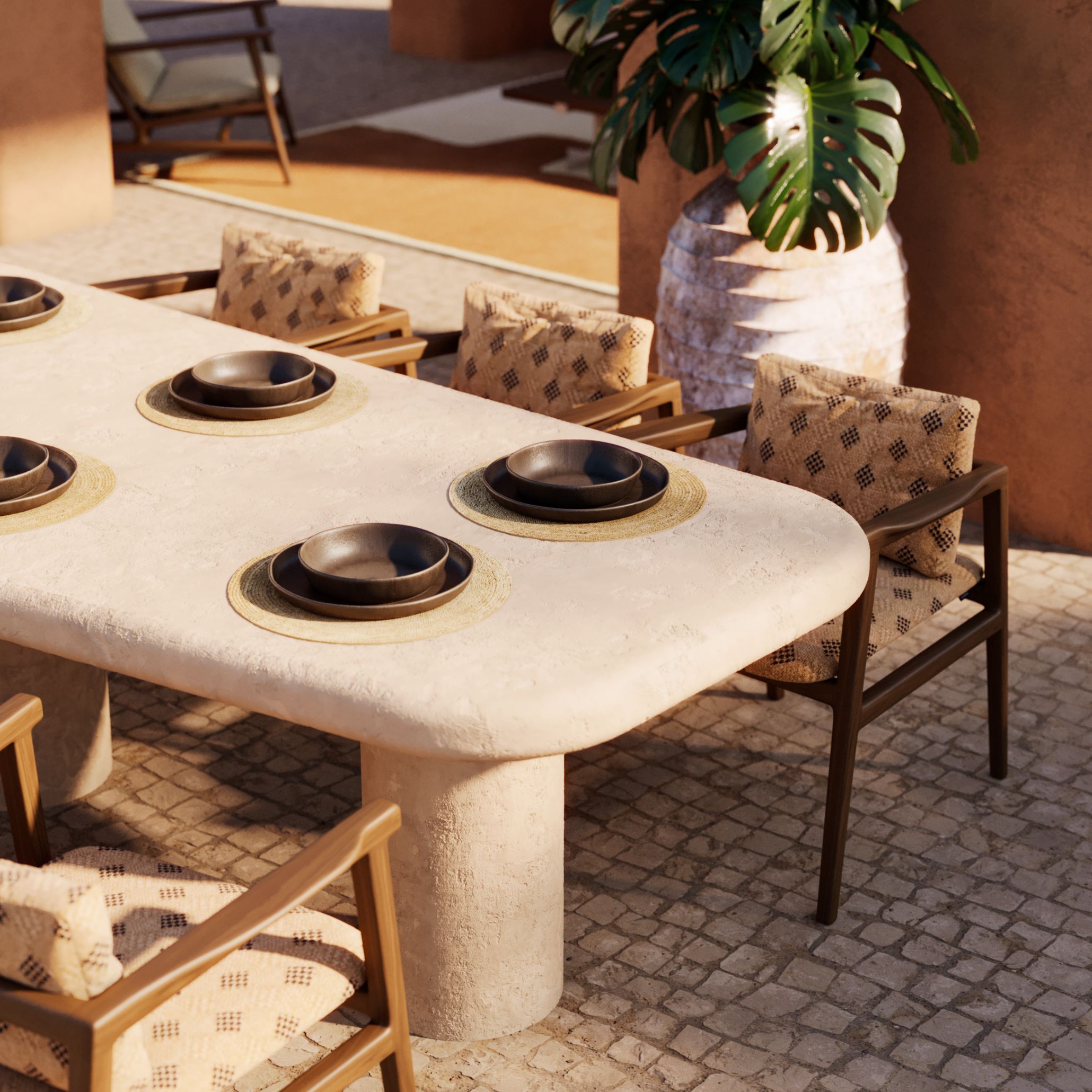 Close-up of the Natur Dining Table's textured stone surface with ceramic bowls on rattan placemats, beside the diamond-patterned Toro Chair upholstery, showing the tactile materials suited to relaxed outdoor dining.