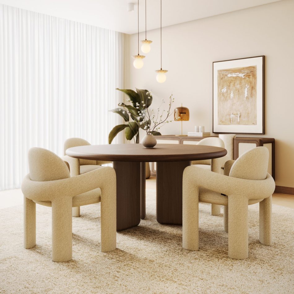 A dining room built around the Foz Dining Table in Alba wood, its round top and sculptural base sitting on a speckled rug beneath a trio of glass pendant lights, surrounded by four cream bouclé Stone Chairs. With a framed painting and dressed console in the background, the scene shows the table functioning as the natural centrepiece for dinning room tables styling within a warm, considered living room design.