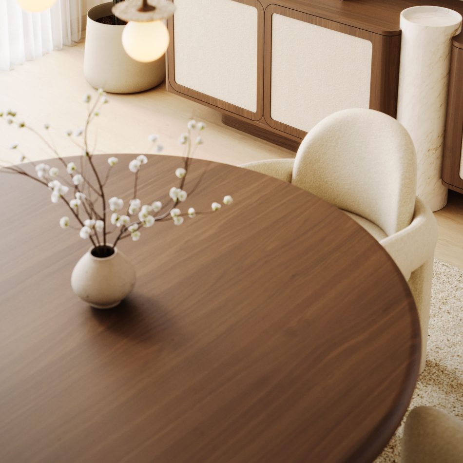 Angled detail of the Foz Dining Table's curved edge in Alba wood, paired with a stoneware vase of white blossoms, set against a walnut sideboard and a Stone Chair in the background. The interplay of warm wood tones and soft bouclé upholstery reflects the kind of interior design inspiration found in a well-composed modern dining table vignette.