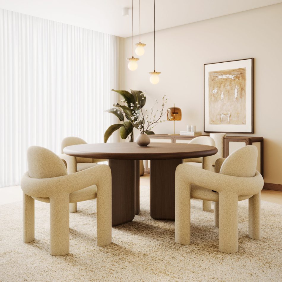A full dining room styled around a round dark-wood table set with four Stone Chairs, their bouclé upholstery and sculptural, curved-arm silhouette anchoring the space beneath a trio of glass pendant lights. Positioned near a framed abstract artwork and a console dressed with foliage and ceramics, the chairs bring a soft, rounded counterpoint to the room's warm wood tones, exemplifying the kind of luxury home furniture styling suited to interior design inspiration projects and refined chair design.