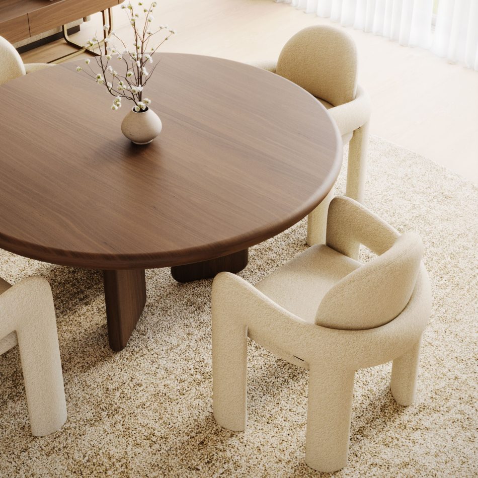 An overhead view of the dining table, its walnut surface holding a small ceramic vase with flowering branches, with two Stone Chairs pulled in close at the table's edge. The chairs' plush bouclé seats and gently curved backrests are shown in fine detail, highlighting the quality of the furniture upholstery and the piece's fit within considered living room furniture arrangements.