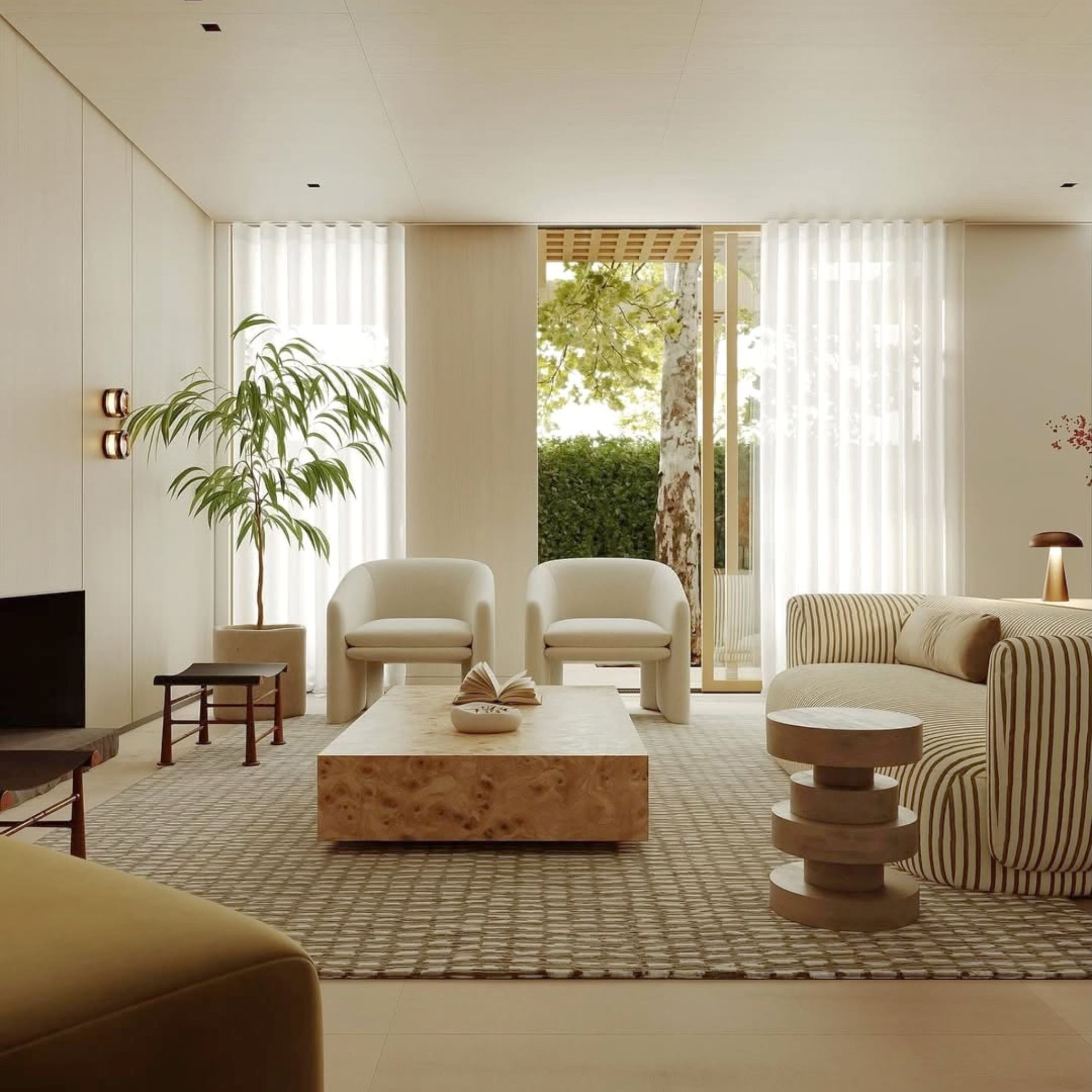 A neutral-toned living room featuring a striped sofa, curved boucle armchairs and a burl wood coffee table opening onto a leafy garden, showcasing luxury living room furniture and living room design within coastal modern interiors.