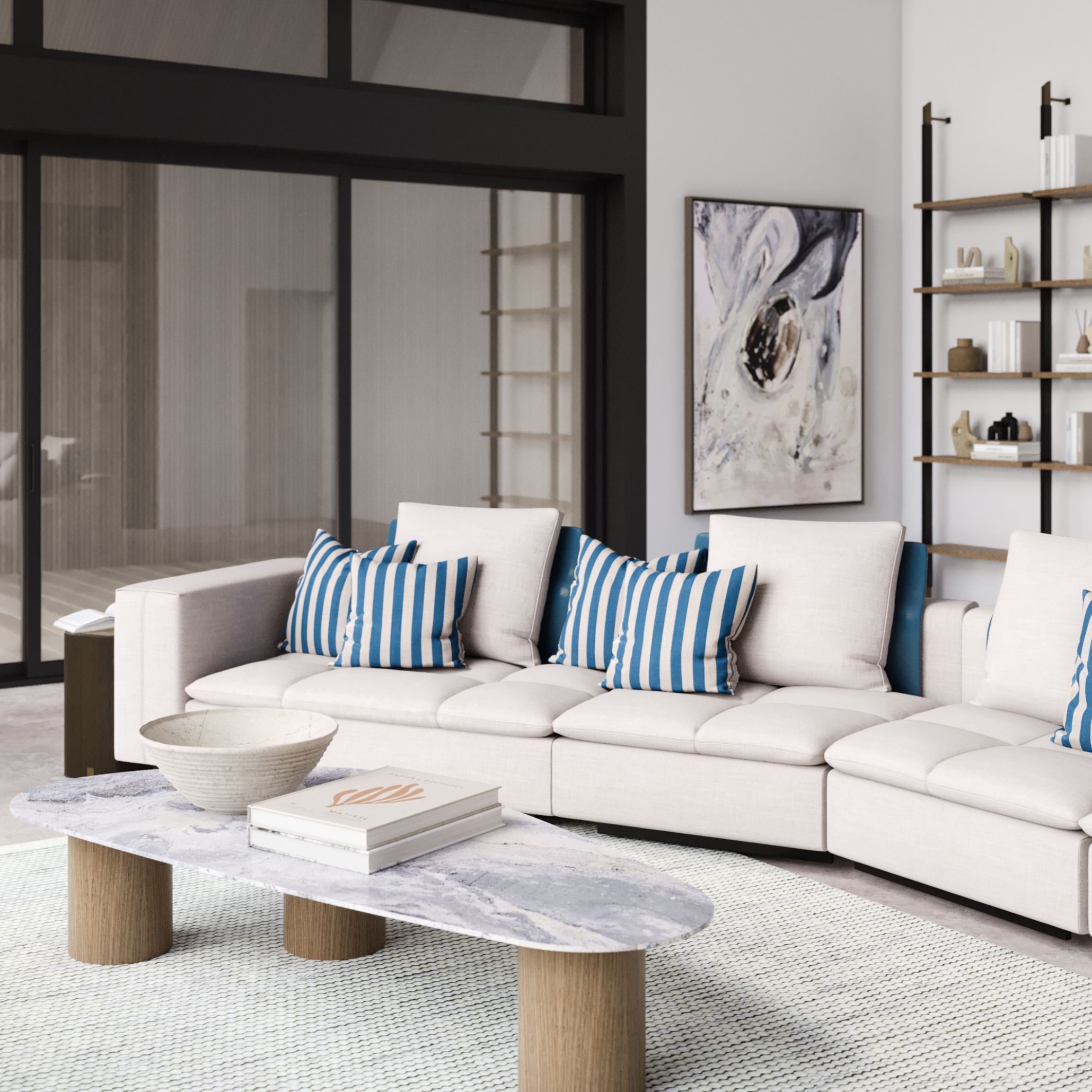 The Margem Sofa in ivory upholstery dressed with blue-and-white striped furniture fabric cushions, set against a marble coffee table and industrial black-framed shelving, an example of luxury living room furniture interpreting Riviera Lines.