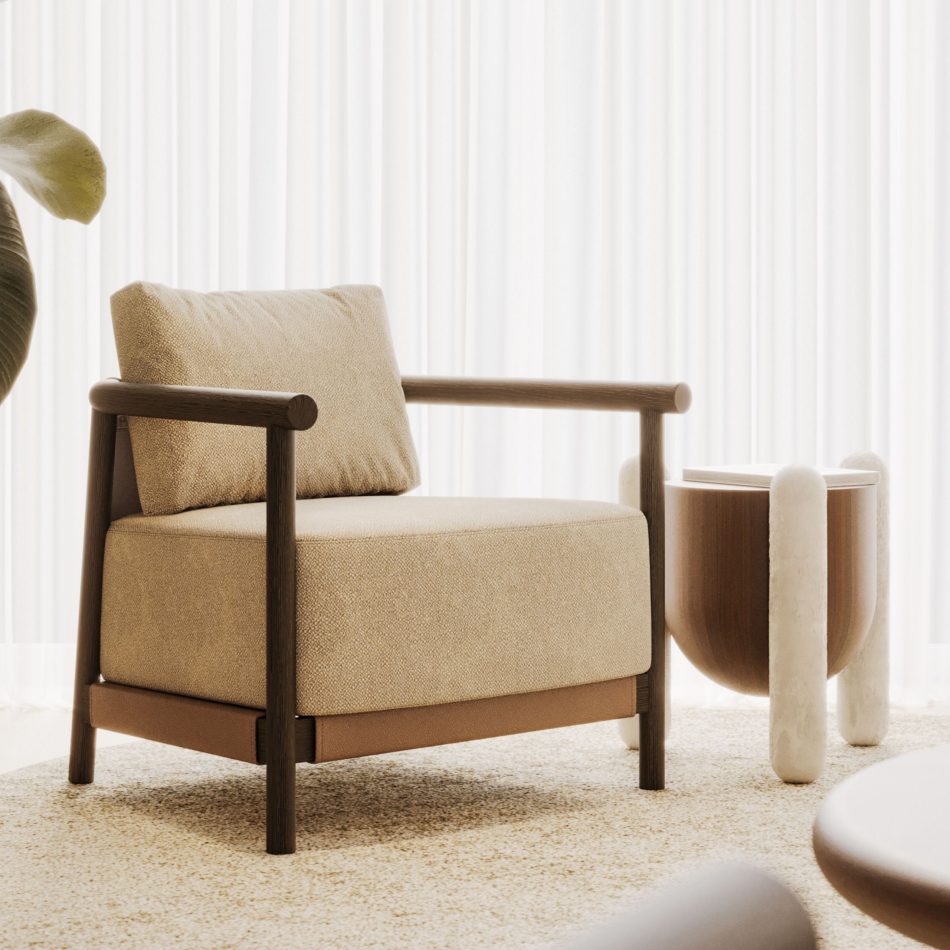 A wider view of the living room, featuring the beige armchair with its wooden frame and leather detailing, set against sheer curtains and soft natural light. The Antónia side table stands just beside it, its rounded marble legs and dark wood top adding a distinctive silhouette to the room. As a piece of contemporary furniture, it complements the space's relaxed, natural palette while introducing its own quiet architectural character.