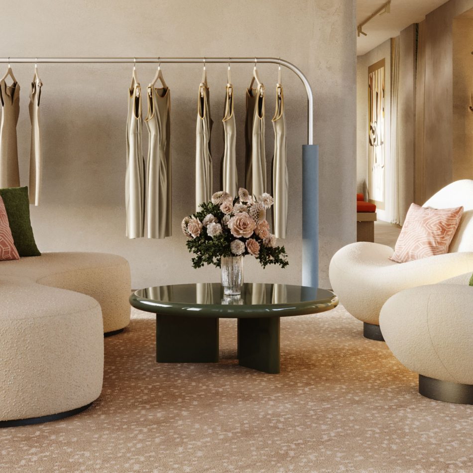 The Foz Coffee Table in a green gloss lacquer sits at the center of a soft, neutral seating area, its rounded silhouette paired with a floral arrangement that adds gentle color. Plush upholstered chairs and a curved sofa frame the scene, creating a warm interior shaped by curated living room furniture and subtle design details. The calm palette and sculptural forms bring a sense of modern luxury furniture into the space, offering quiet interior design inspiration for refined environments.