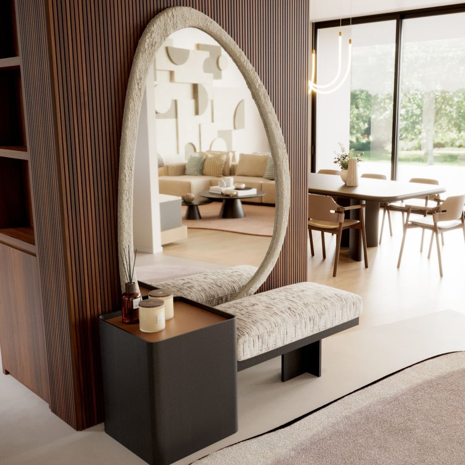 A wide view of an open plan entrance hall leading into a dining area, with wood panelling, soft neutral tones, and natural light pouring in from the garden facing windows. The tall, oval shaped mirror in raw microconcrete stands out against the timber wall, its organic curve softening the otherwise structured lines of the furniture around it. As a piece of contemporary furniture, it reflects the adjoining rooms while introducing the gentle, minimalist design language that runs throughout the home.