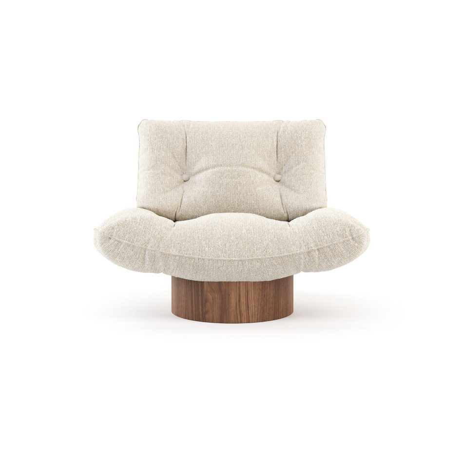 Broad upholstered Antónia armchair in soft cream fabric over a round wood base, showcasing a minimalist design approach to luxury furniture.