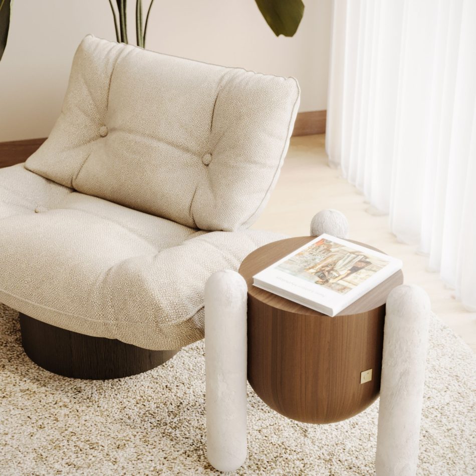 Soft tufted upholstery and dark wood base of the Antónia armchair, reflecting fine craftsmanship beside a contemporary side table.