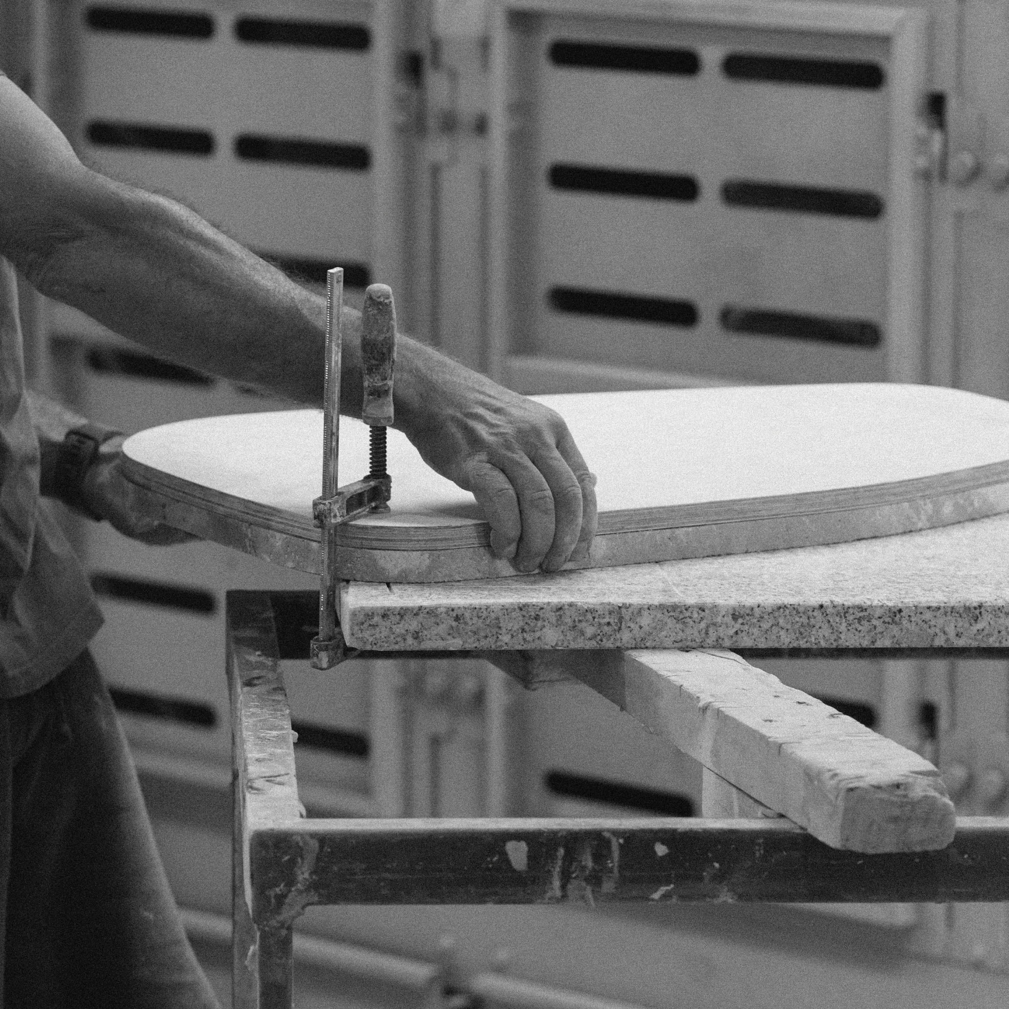 Craftsman using a clamp during production, demonstrating the best handmade techniques used to craft bespoke furniture, handmade furniture, and luxurious furniture.