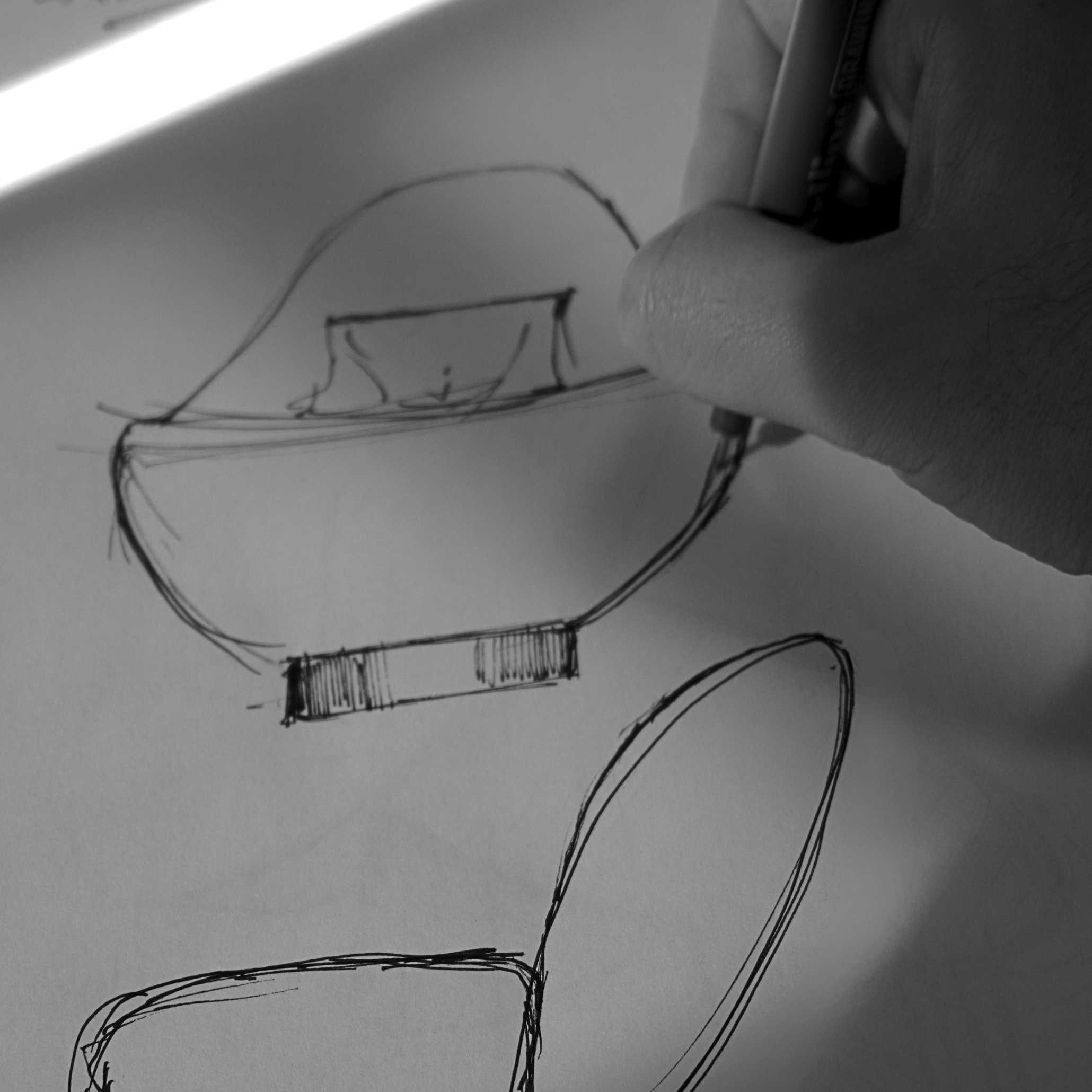 Hand drawing the rounded silhouette of the Stone Armchair, creating sofa design for lobby spaces, bespoke living room concepts, and luxury living room furniture.